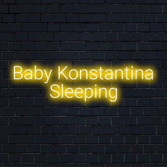 Baby Konstantina Sleeping Personalized LED Neon Sign, bright neon lettering on dark brick wall