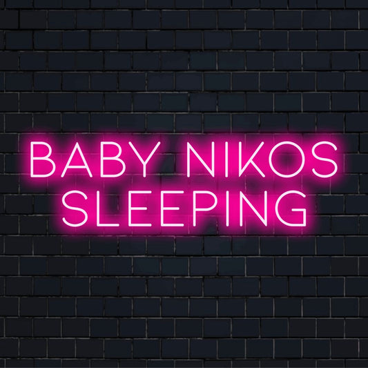 Baby Nikos Sleeping Personalized Neon Light with glowing wall decor on dark brick background
