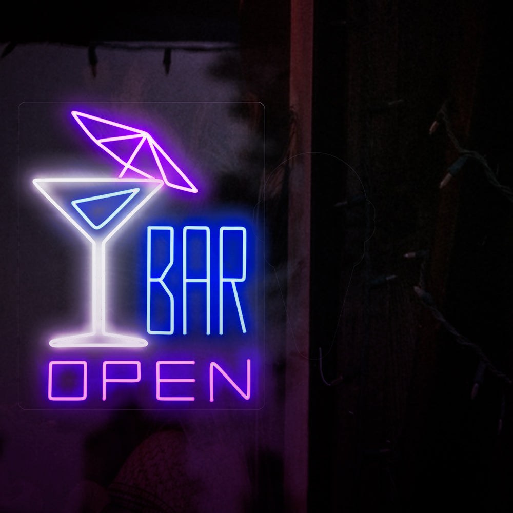 Op de foto is een neonreclame te zien met links een cocktail met een parasol en rechts de tekst 'open bar'. Deze neonreclame is ideaal voor bars, zowel binnen als buiten.
