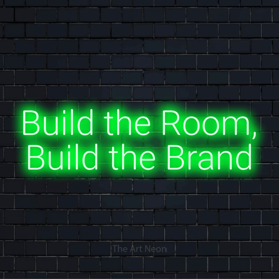 "Build The Room, Build The Brand" glowing LED neon sign on a black brick wall