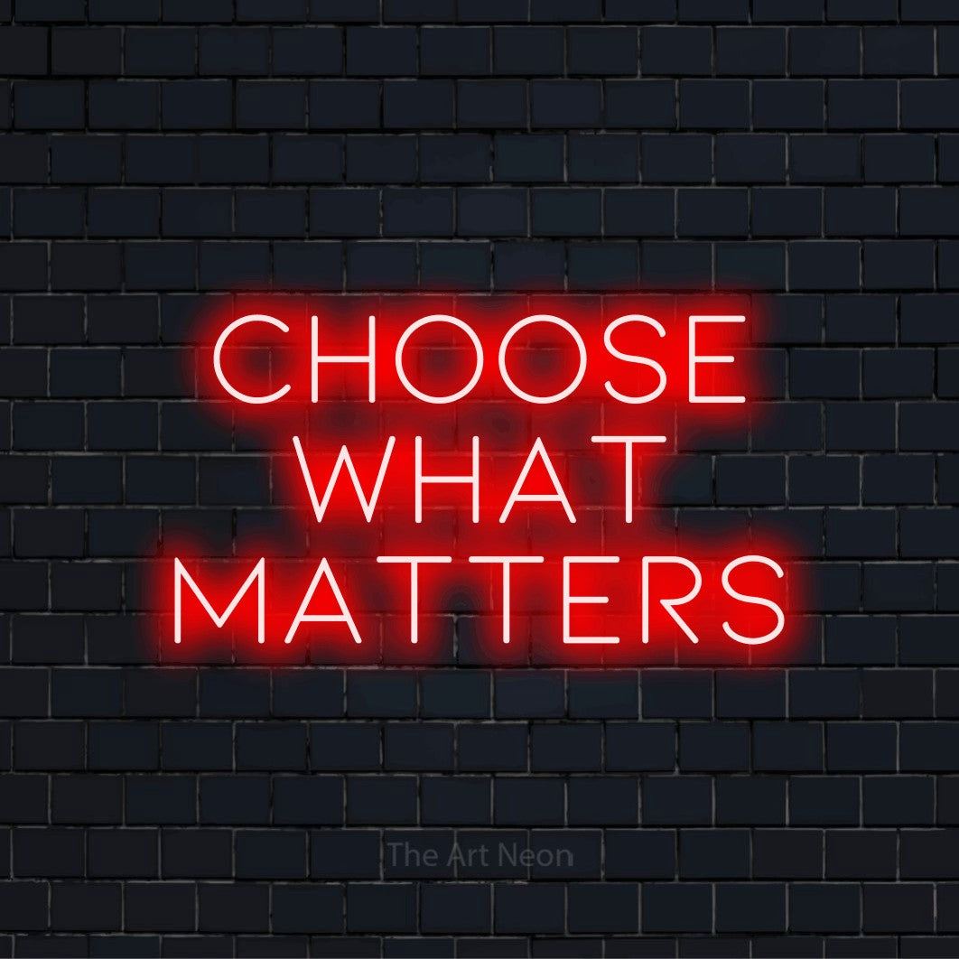 "Choose What Matters" script-style LED neon sign on a black brick wall