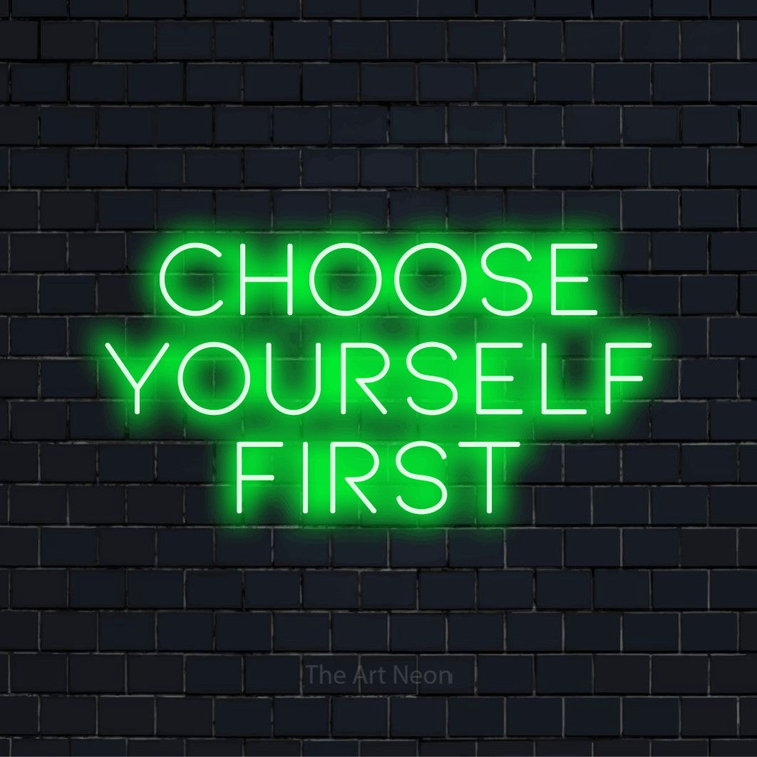 "Choose Yourself First" text design with neon effect on a black brick wall