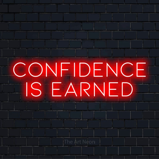 "Confidence Is Earned" script-style LED neon sign on a black brick wall