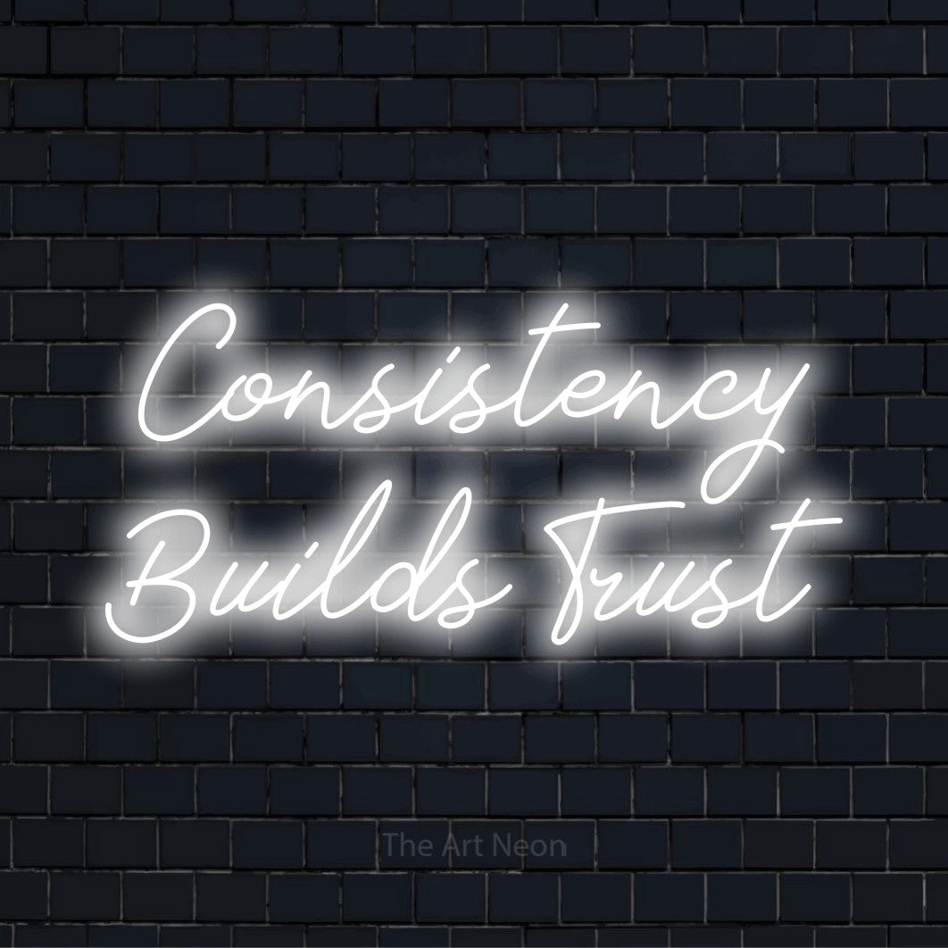 "Consistency Builds Trust" glowing LED neon sign on a black brick wall