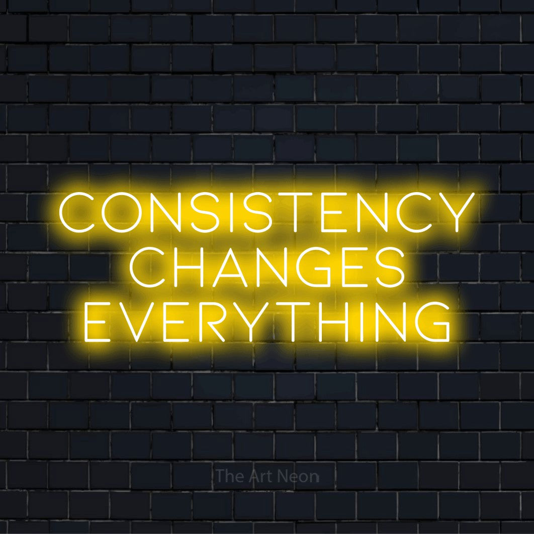 "Consistency Changes Everything" glowing LED neon sign on a black brick wall