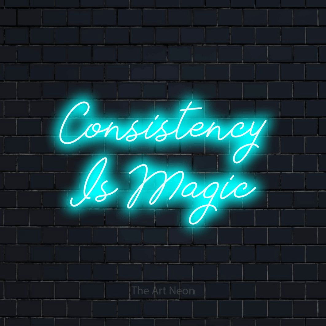 "Consistency Is Magic" glowing LED neon sign on a black brick wall