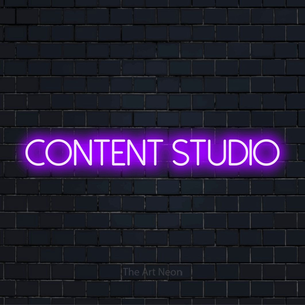 "Content Studio" script-style LED neon sign on a black brick wall