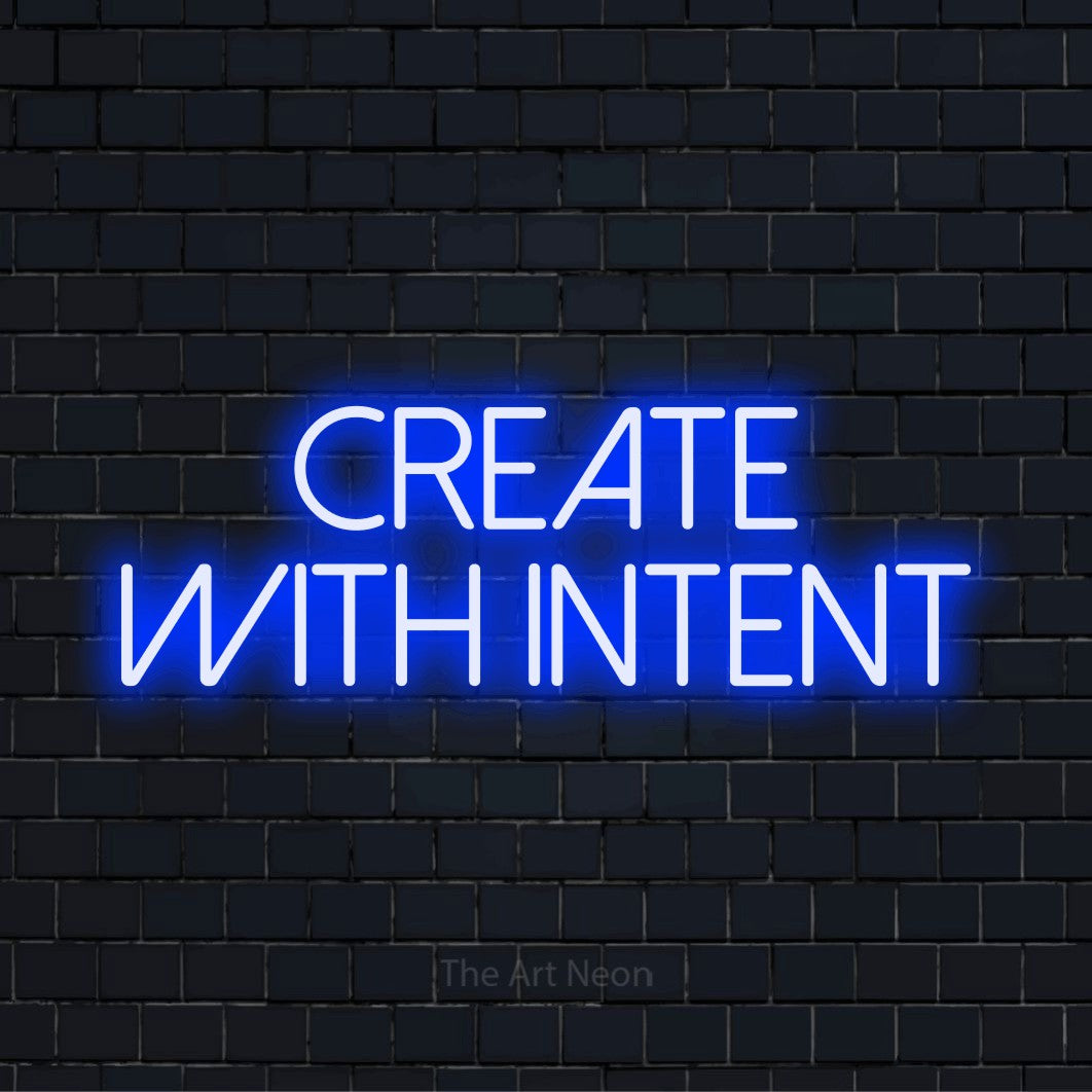 "Create With Intent" glowing LED neon sign on a black brick wall