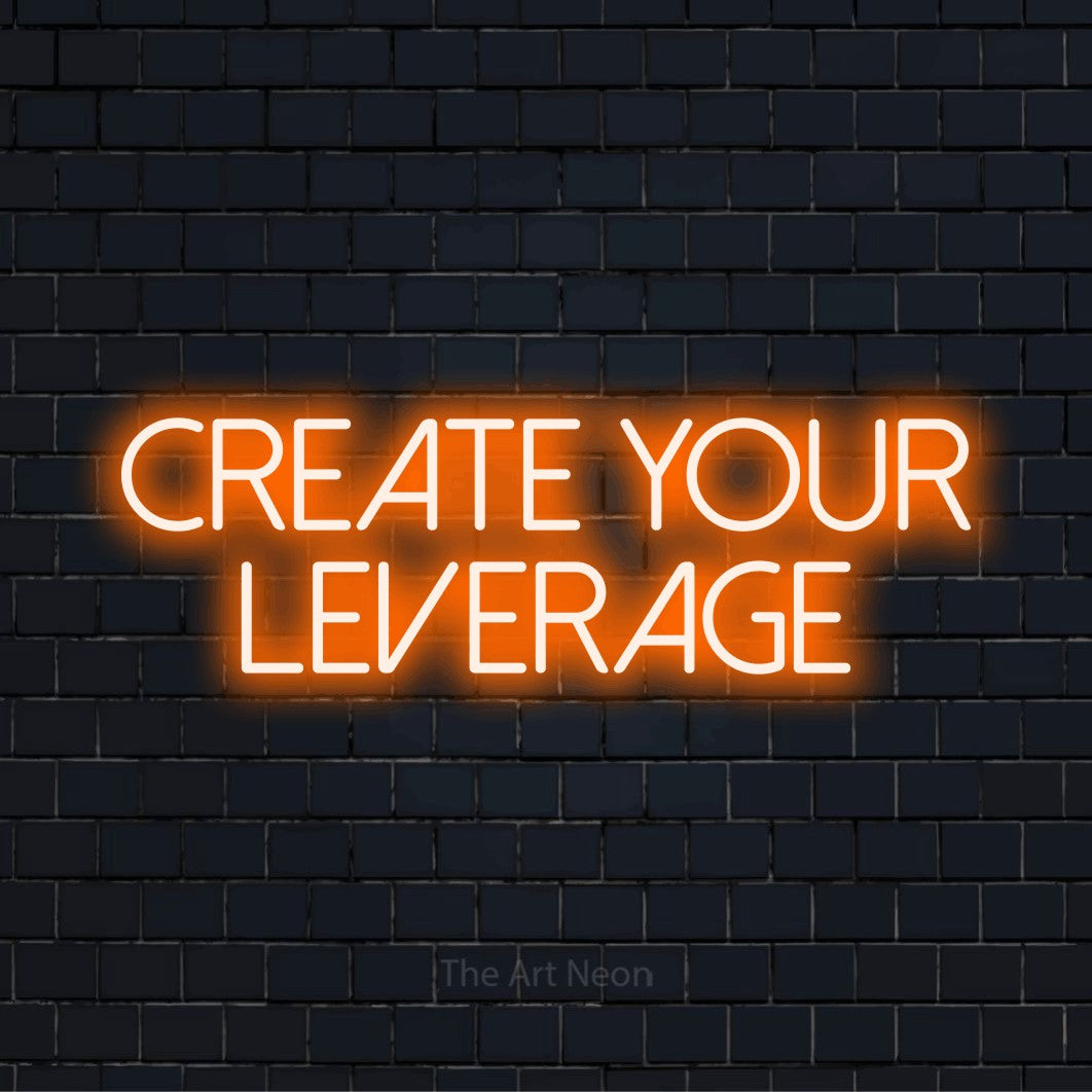 "Create Your Leverage" script-style LED neon sign on a black brick wall
