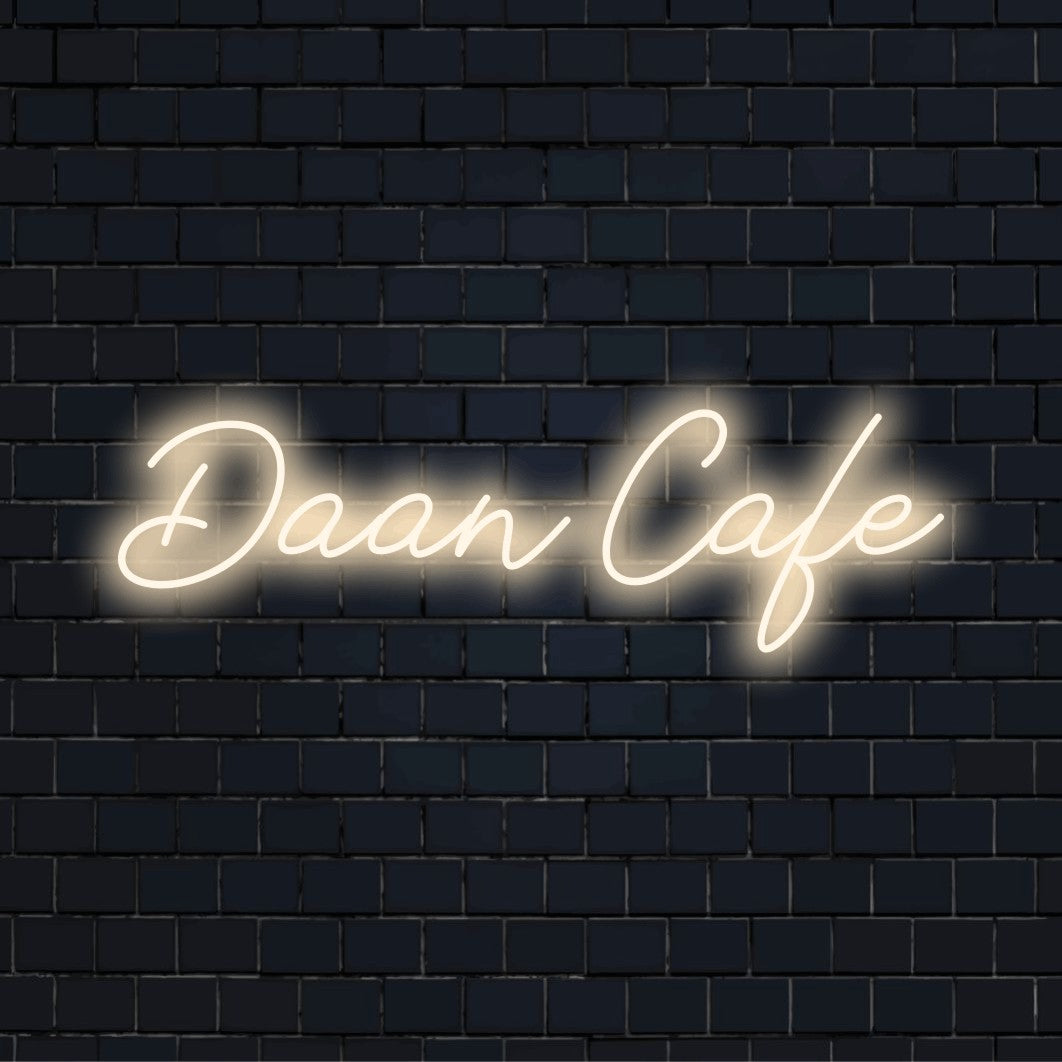 Daan Cafe Custom Name Neon Sign, glowing lettering against black brick wall