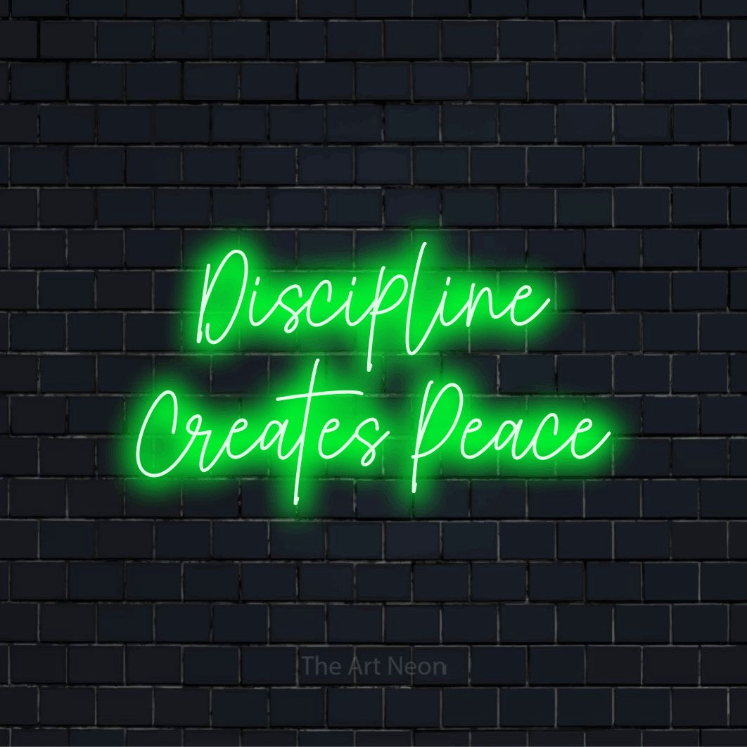 "Discipline Creates Peace" script-style LED neon sign on a black brick wall