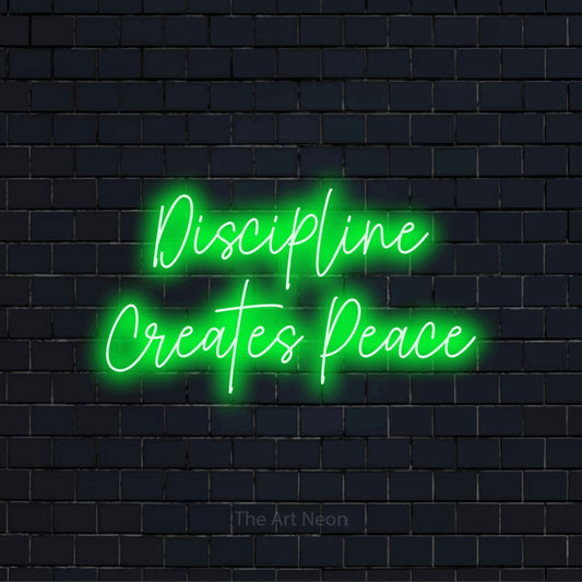"Discipline Creates Peace" script-style LED neon sign on a black brick wall