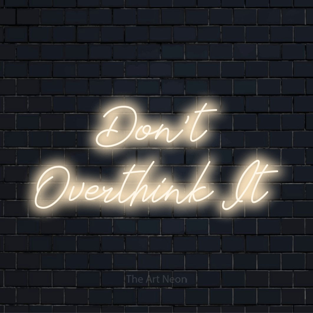 "Don’t Overthink It" glowing LED neon sign on a black brick wall