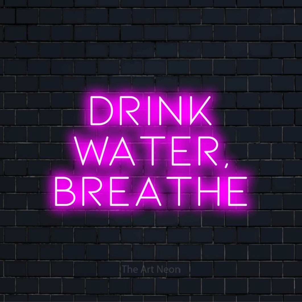 "Drink Water, Breathe" LED neon sign on a black brick wall