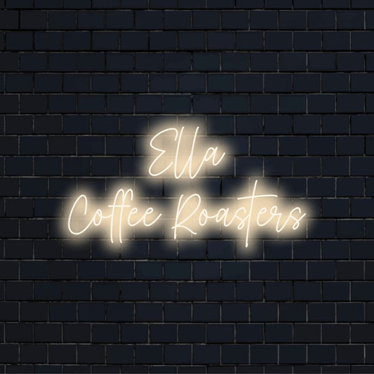 Ella Coffee Roasters Custom Name Neon Sign, bright neon lettering against black brick wall