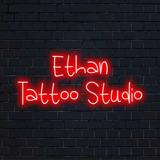 Ethan Tattoo Studio Custom Name Neon Sign, bright neon glow against black brick wall