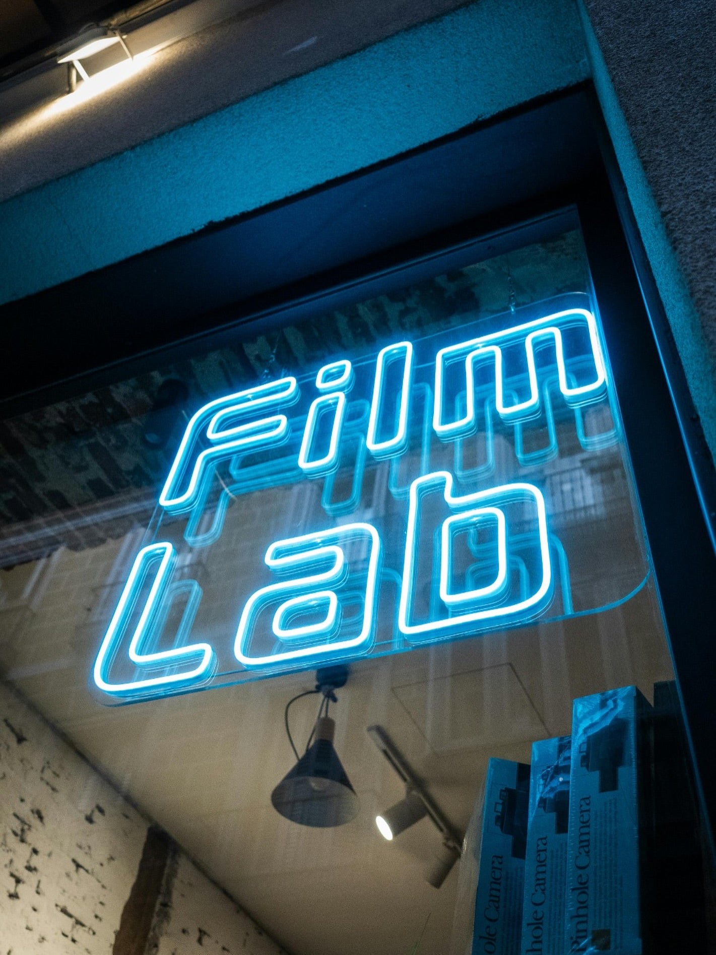 Blue Film Lab LED neon logo installed inside a street-facing storefront window
