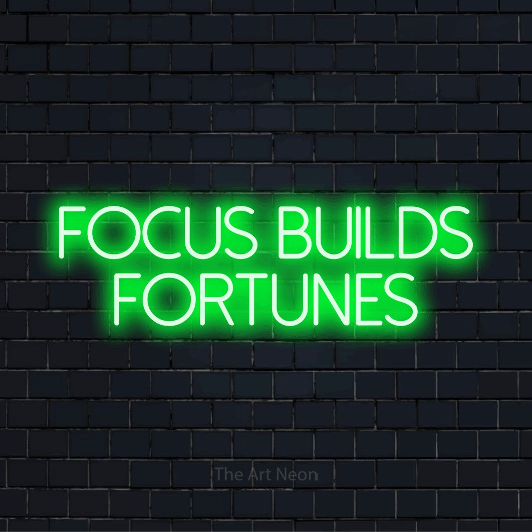 "Focus Builds Fortunes" neon text design on a black brick wall