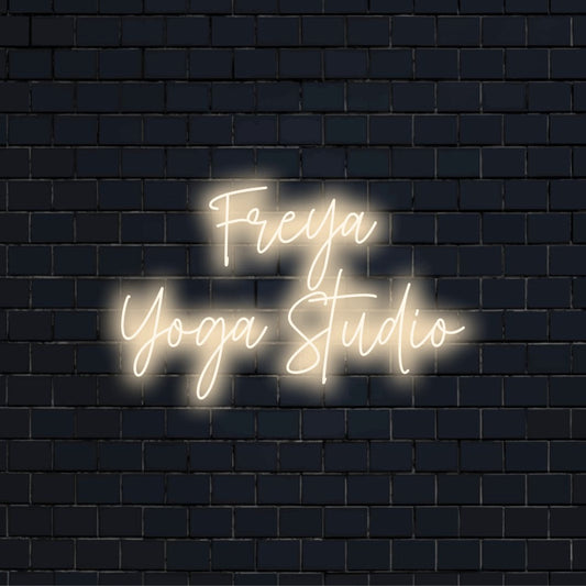 Freya Yoga Studio Custom Name Neon Sign, glowing wall decor on dark brick wall