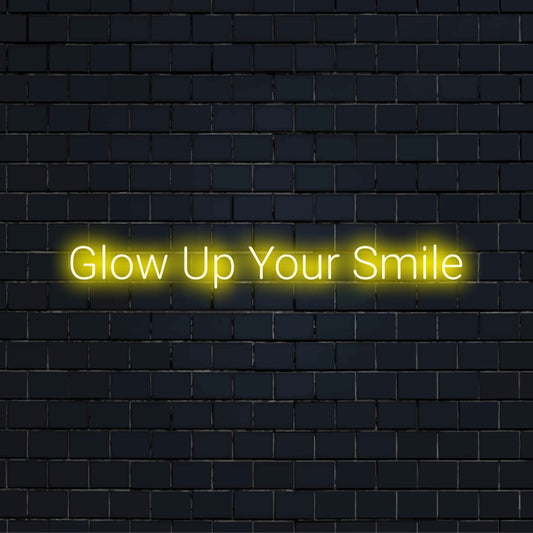 Glow Up Your Smile Neon Light with bright neon lettering on black brick background
