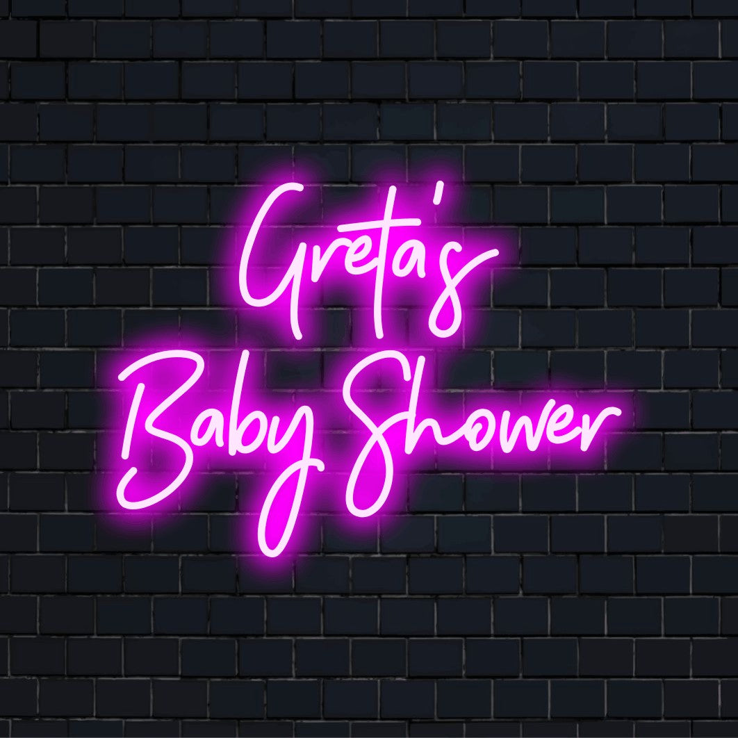 Greta_s Baby Shower Custom Name Neon Sign, bright LED glow against black brick wall