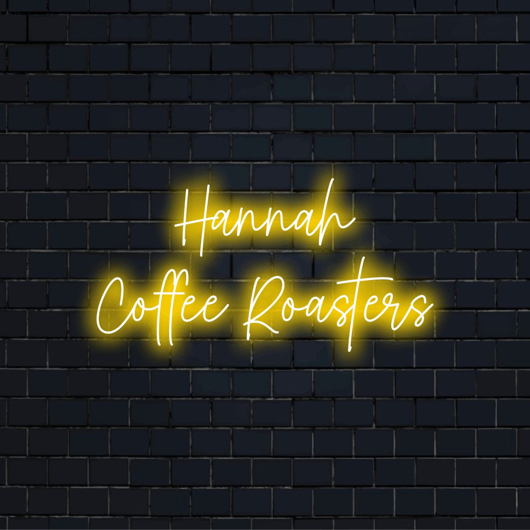 Hannah Coffee Roasters Custom Name Neon Sign, bright neon glow against black brick wall