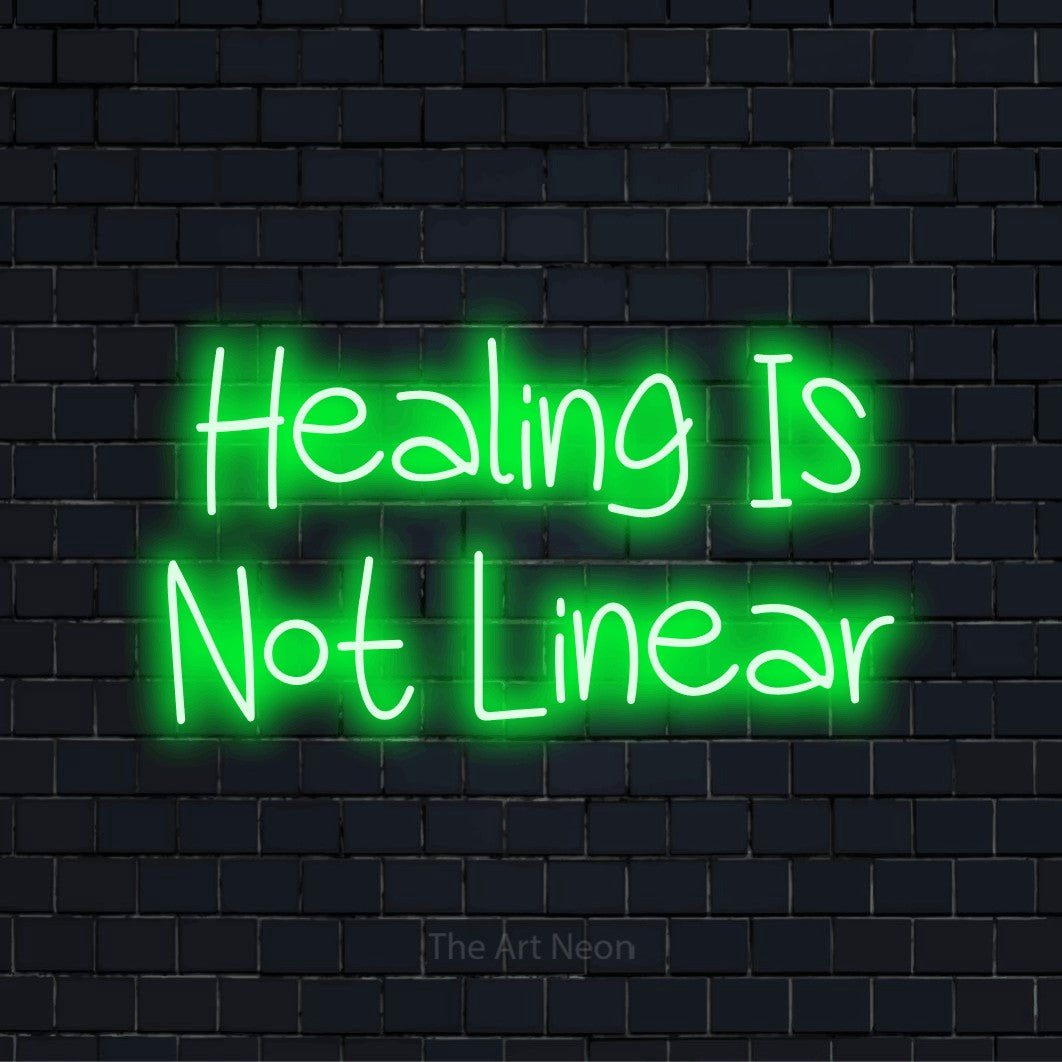 "Healing Is Not Linear" LED neon sign on a black brick wall