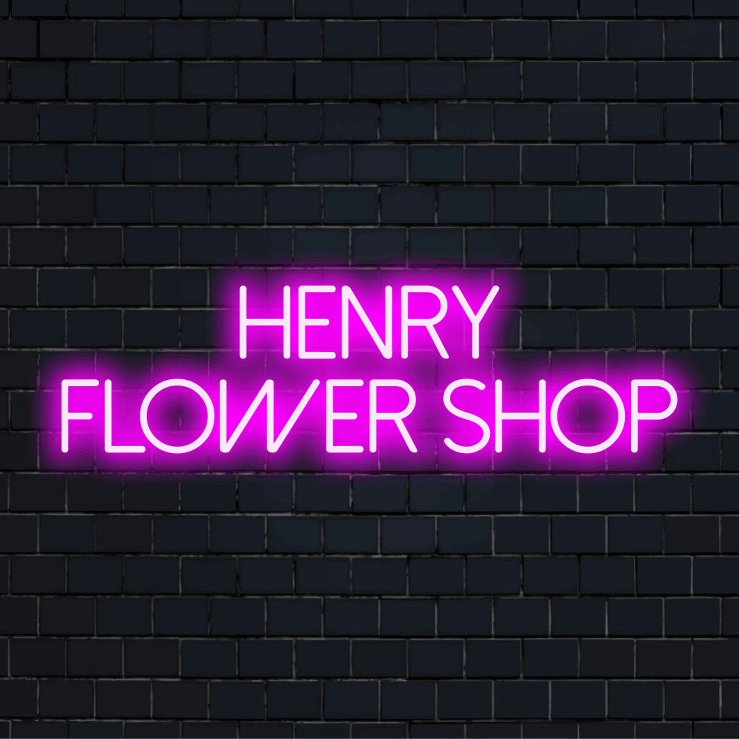 Henry Flower Shop Personalized Neon Light with neon text light against brick backdrop