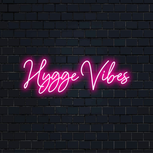 Hygge Vibes Neon Light with soft neon glow against black brick wall