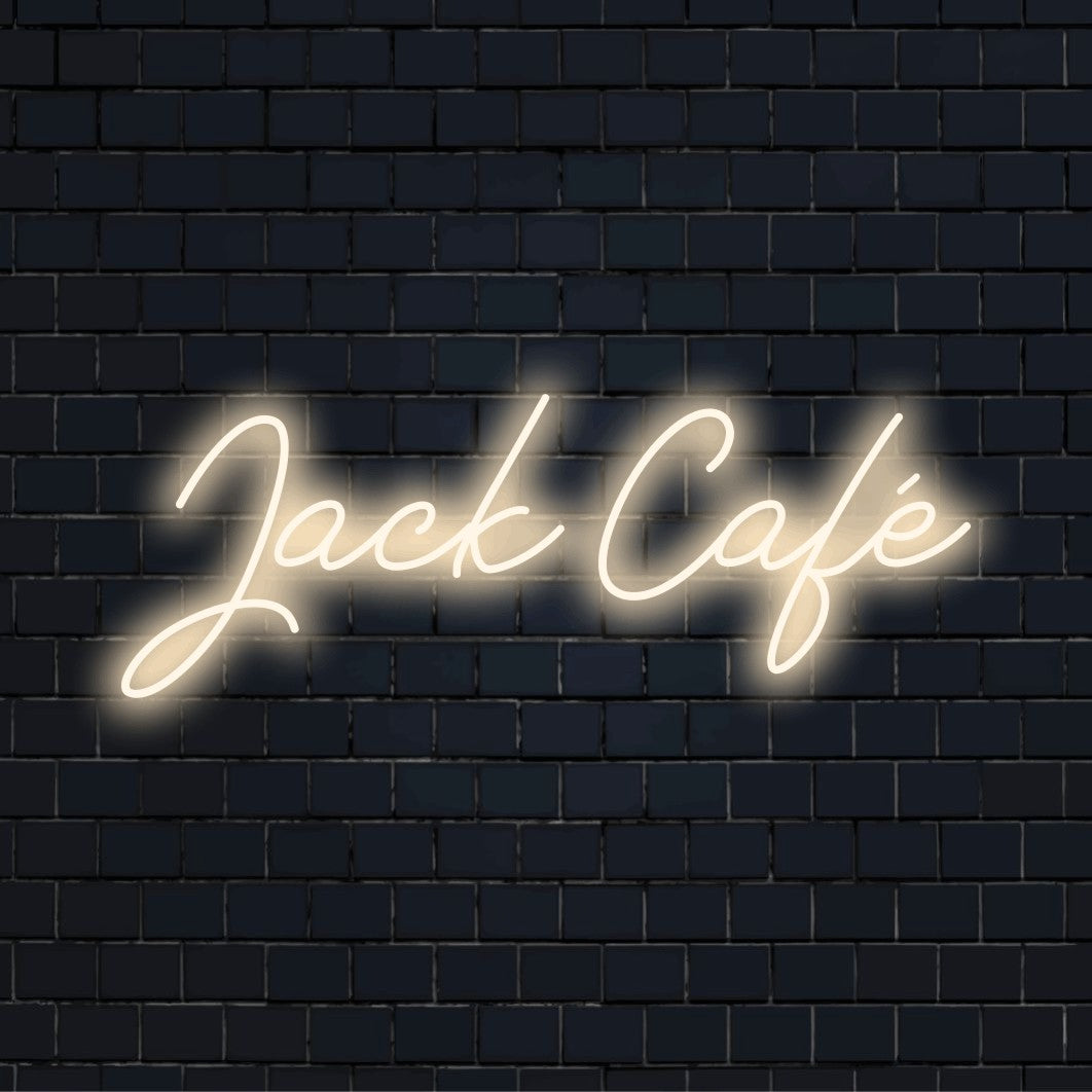 Jack Cafe Personalized Neon Light with bright neon glow against brick backdrop