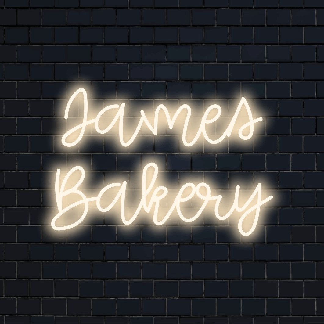 James Bakery Personalized LED Neon Sign, glowing neon text against black brick wall