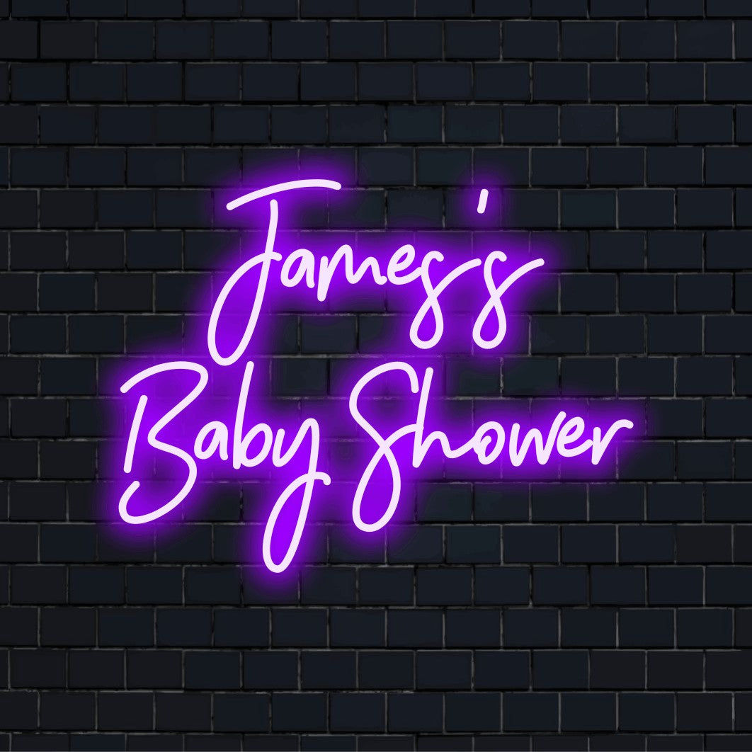 James_s Baby Shower Custom Name Neon Sign, glowing lettering against black brick wall