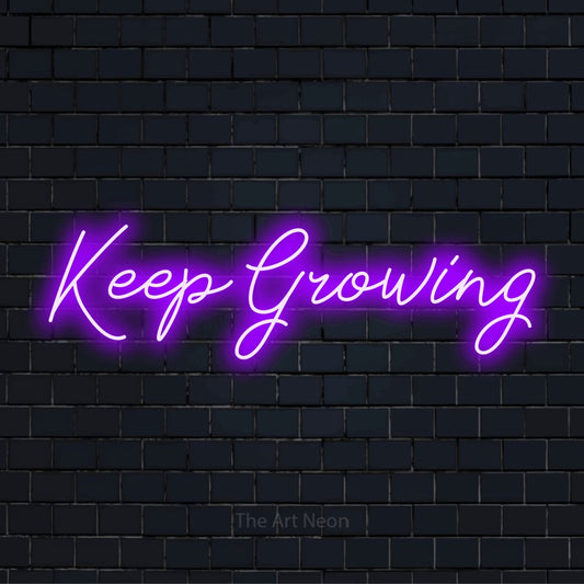 "Keep Growing" glowing LED neon sign on a black brick wall
