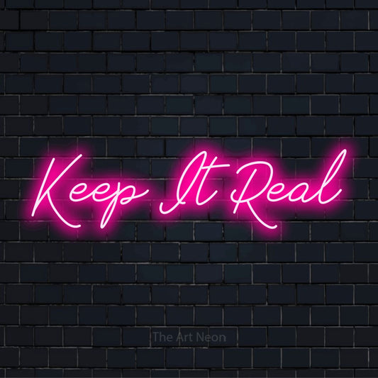 "Keep It Real" glowing LED neon sign on a black brick wall