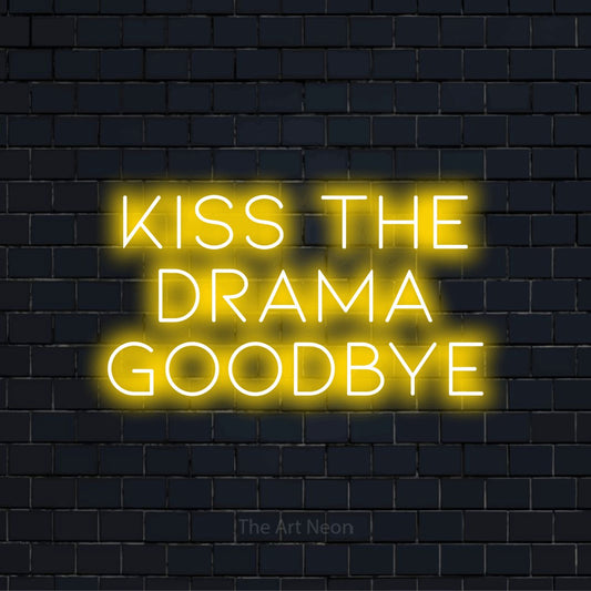"Kiss The Drama Goodbye" glowing LED neon sign on a black brick wall