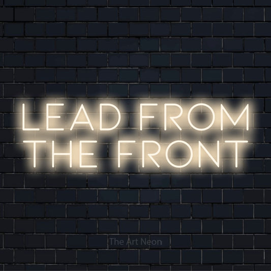 "Lead From The Front" LED neon sign on a black brick wall