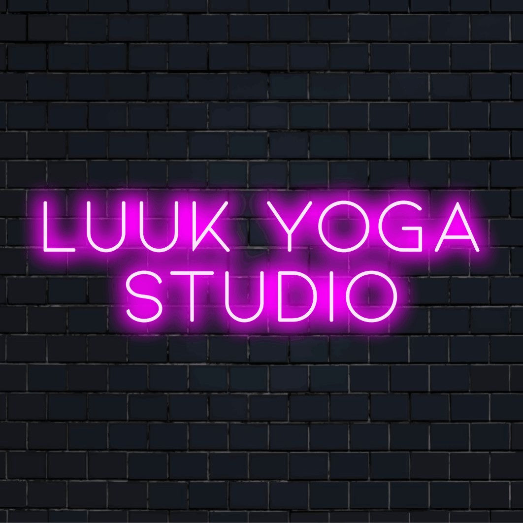Luuk Yoga Studio Personalized Neon Light with glowing neon text on dark brick wall