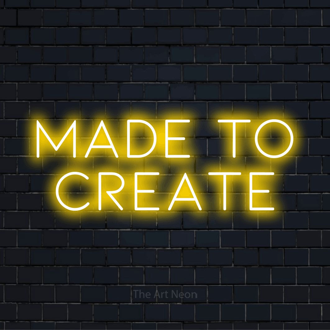 "Made To Create" neon text design on a black brick wall