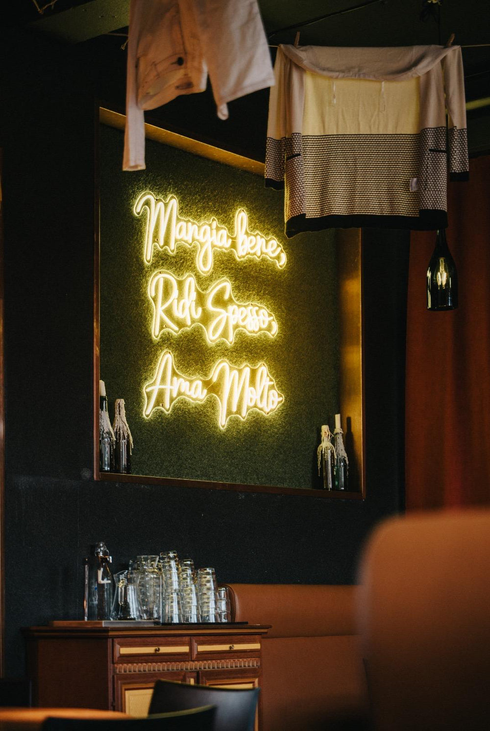 Close view of a green LED neon sign above a restaurant booth