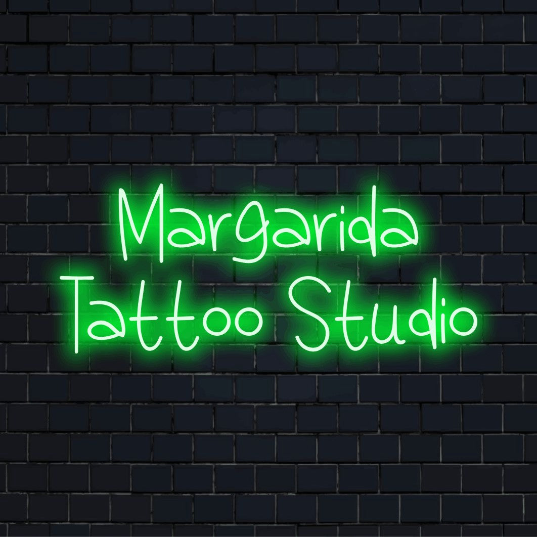 Margarida Tattoo Studio Personalized Neon Light with glowing neon text against brick backdrop