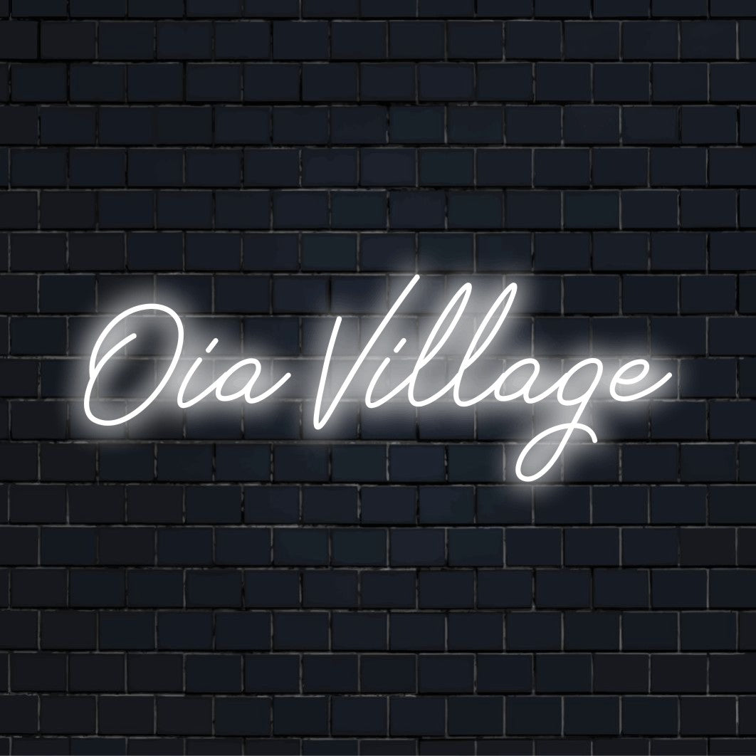 Oia Village Neon Light with glowing lettering on dark brick background