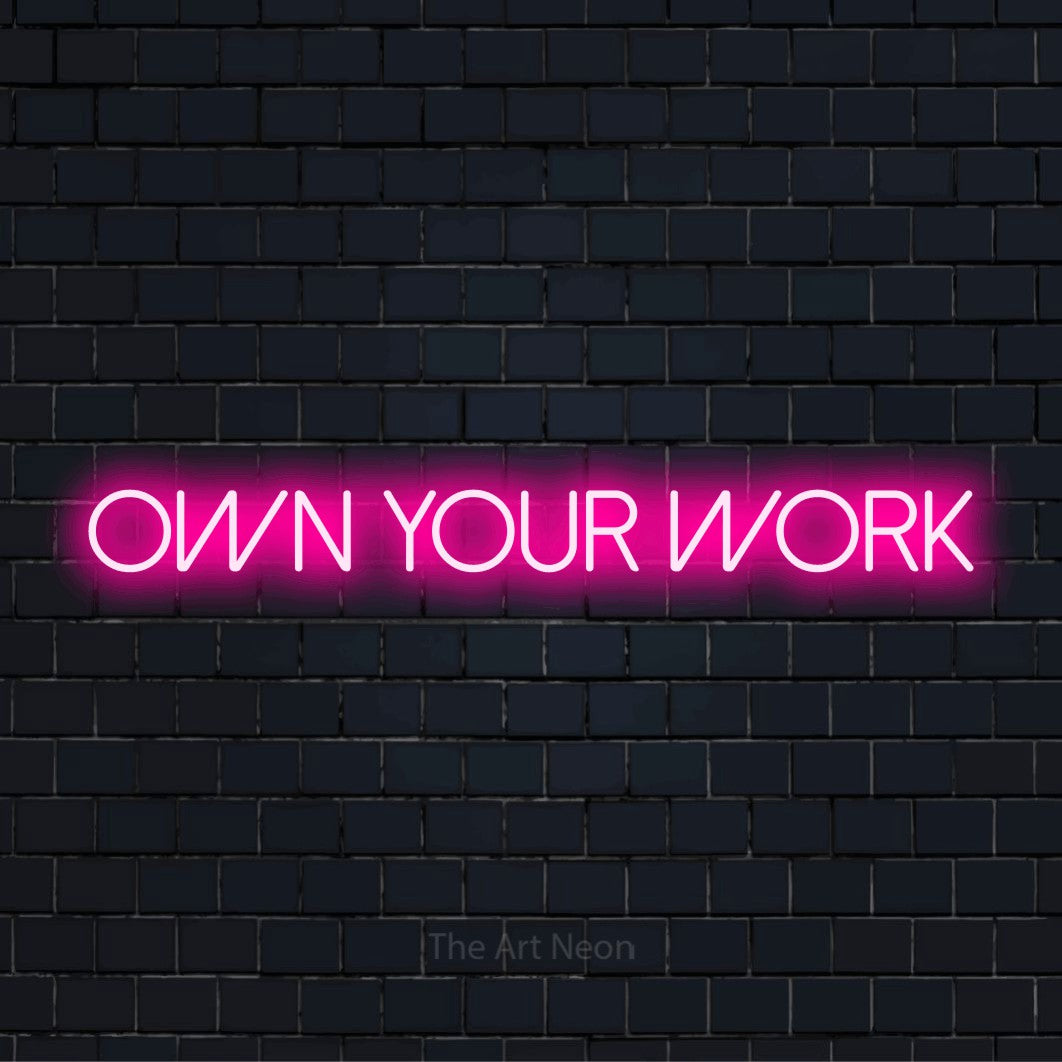 "Own Your Work" text design with neon effect on a black brick wall