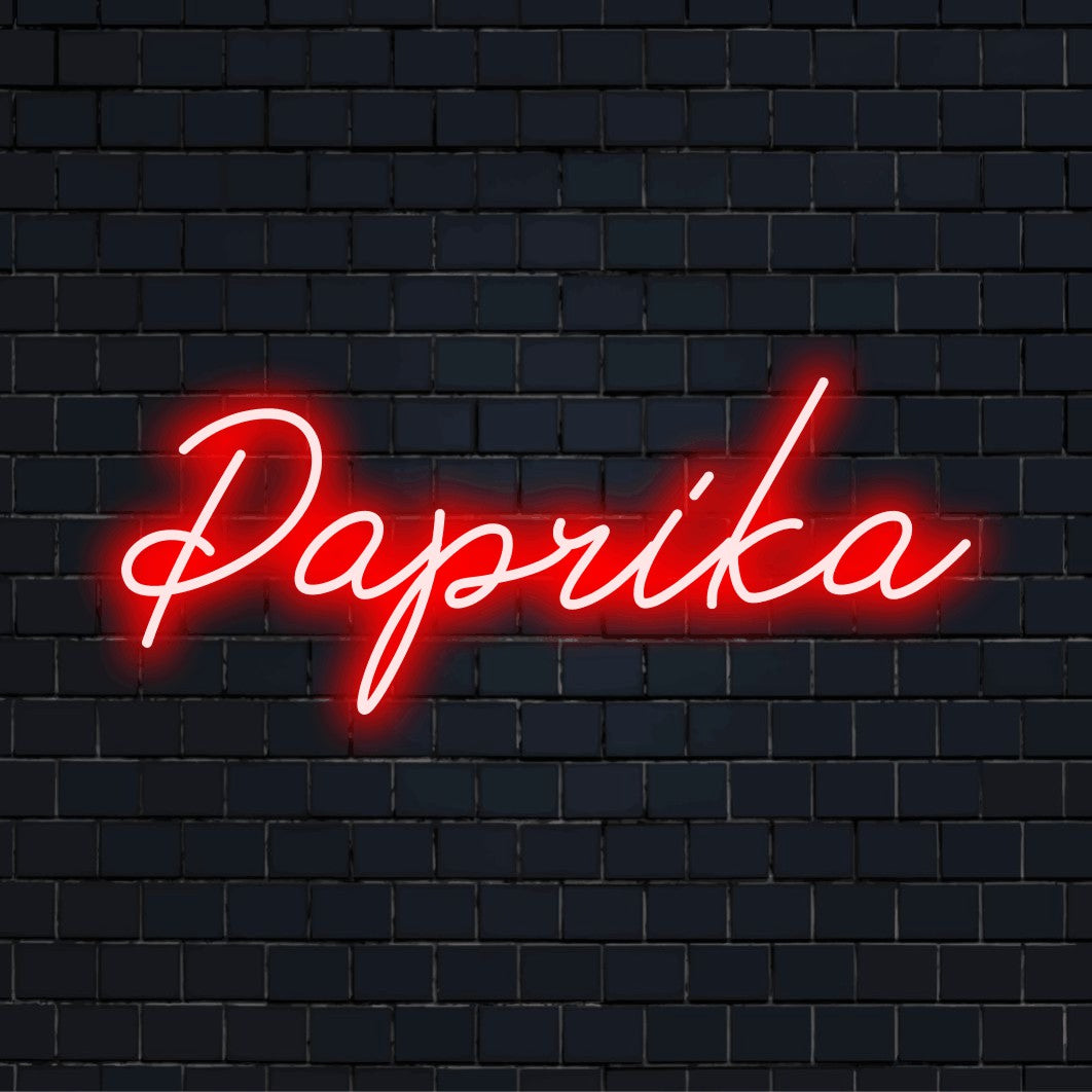 Paprika LED Neon Sign, glowing neon text against black brick wall