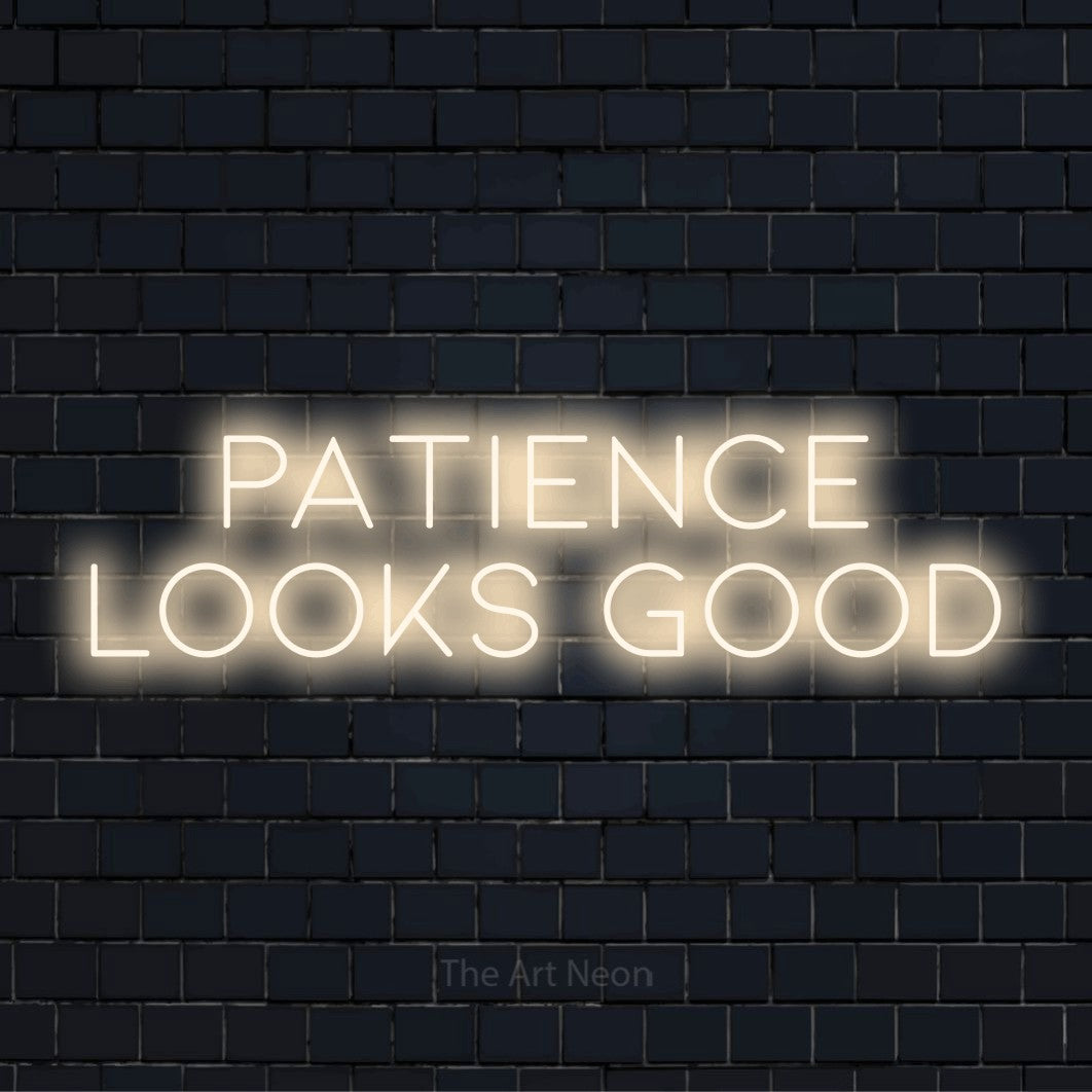 "Patience Looks Good" LED neon sign on a black brick wall