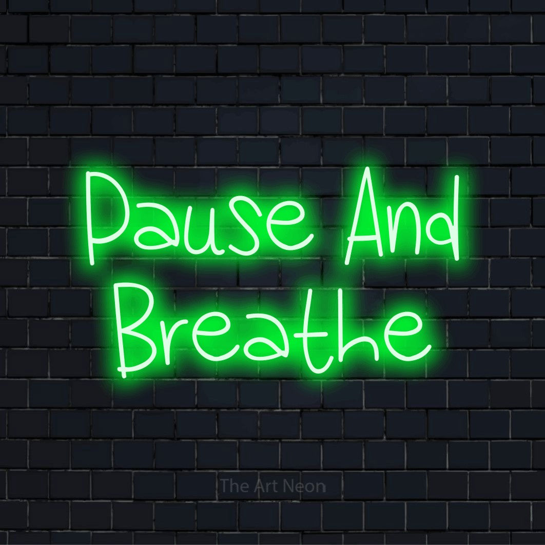 "Pause And Breathe" LED neon sign on a black brick wall