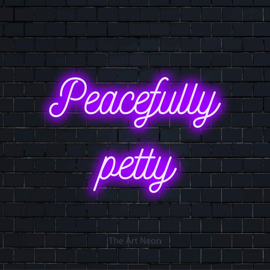 "Peacefully Petty" LED neon sign on a black brick wall