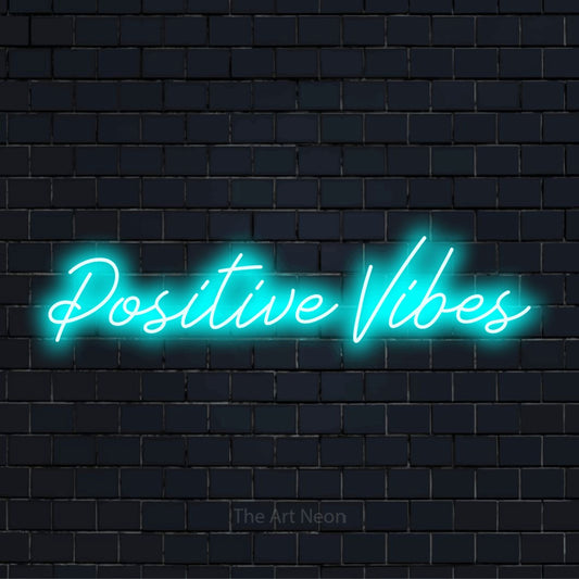 "Positive Vibes" neon text design on a black brick wall