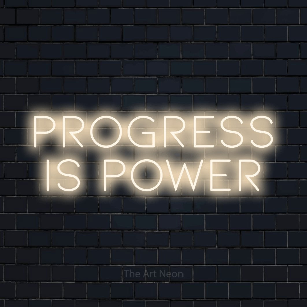"Progress Is Power" LED neon sign on a black brick wall