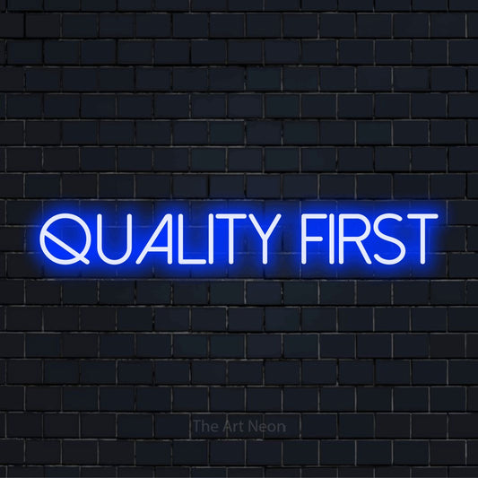 "Quality First" LED neon sign on a black brick wall