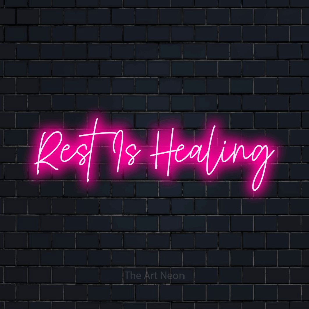 "Rest Is Healing" glowing LED neon sign on a black brick wall